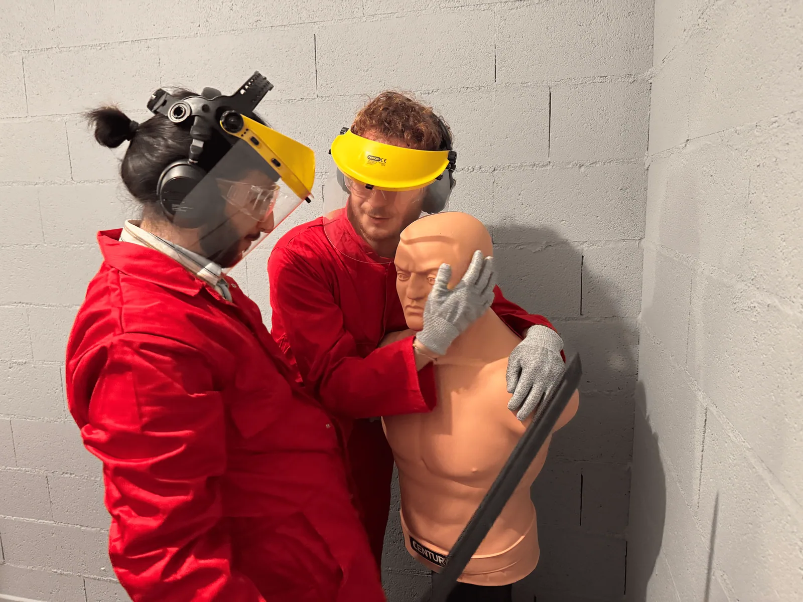 Deux participants équipés dans la Rage Room avec le mannequin de combat
